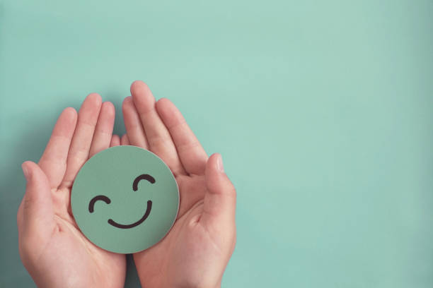 hands-holding-green-happy-smile-face-paper-cut-good-feedback-rating-and-positive-customer